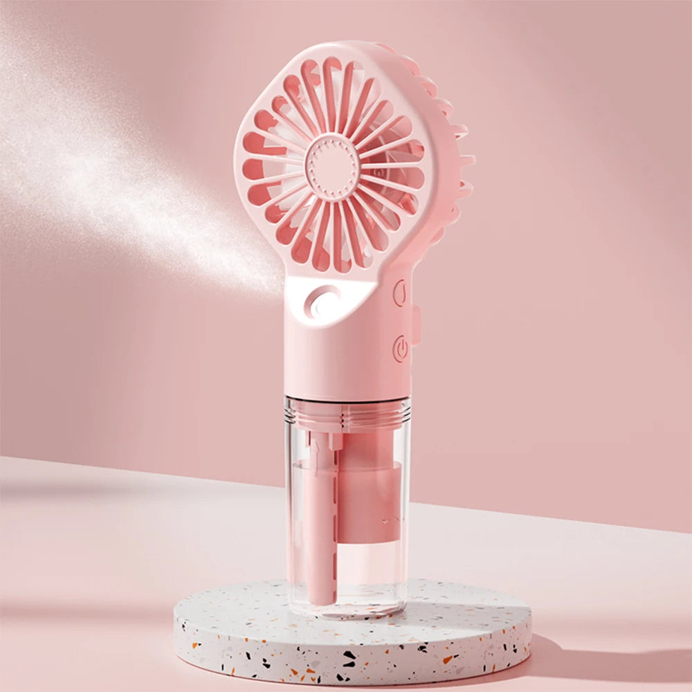 Pink handheld mist fan on stand with round grille and visible water compartment