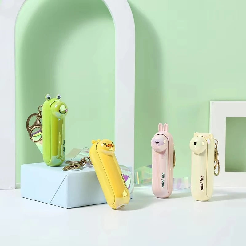 Mini handheld keychain fan set with green, yellow, pink, and white units on display.
