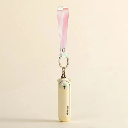Pale pink mini handheld keychain fan with ribbon strap and metal key ring, side view.